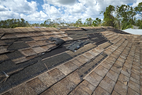 Damaged house roof with missing shingles